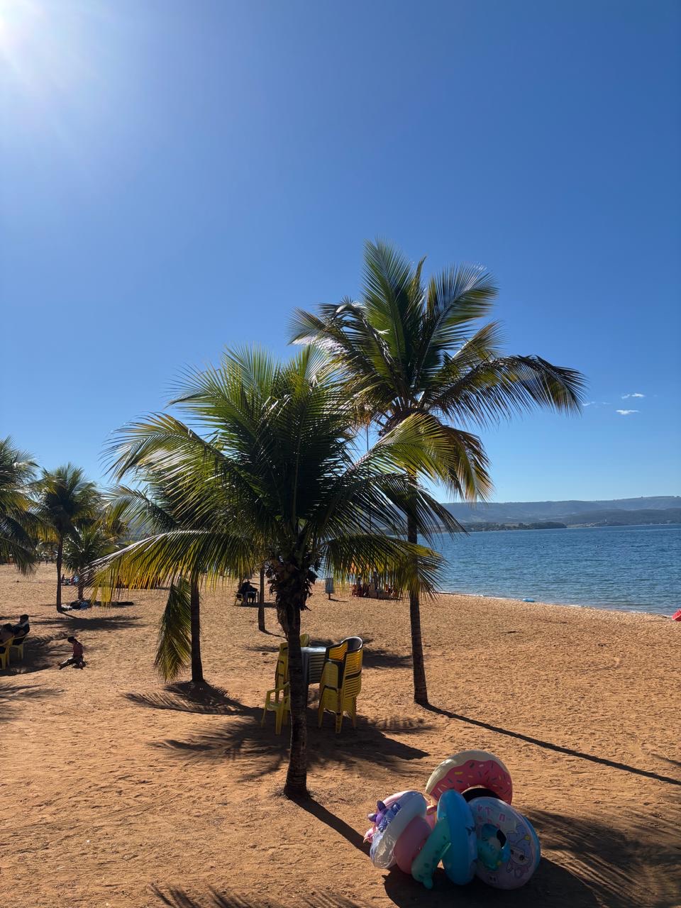 Praia de água doce em Rifaina, com palmeiras e areia dourada à beira da represa.